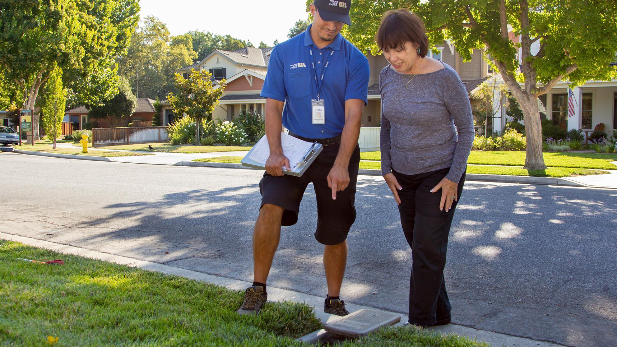 SJW customer and worker outside examining a property.